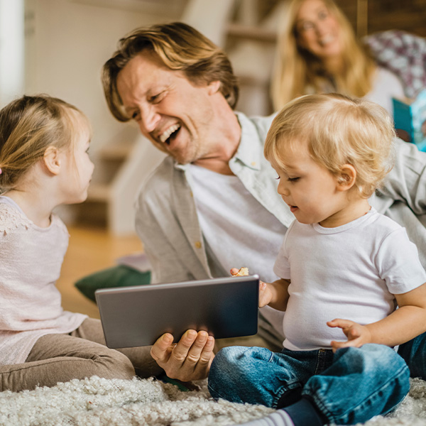 Father and two daughters playing on floor